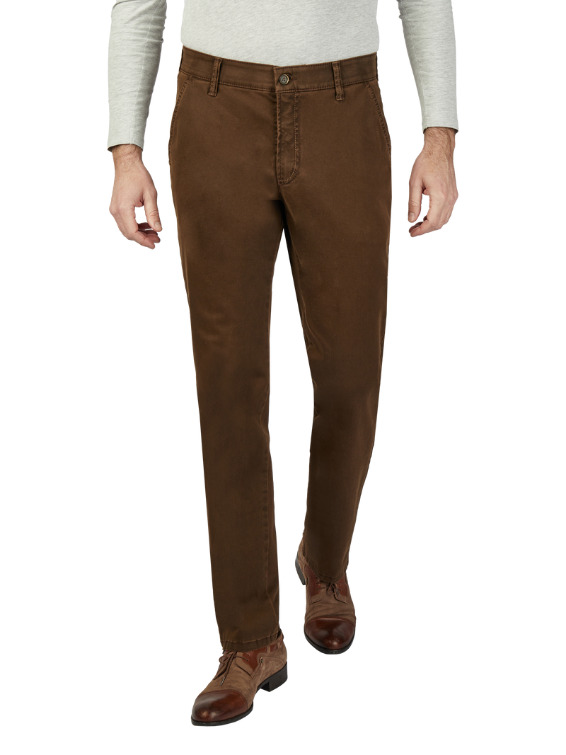 Absatzreiche braune Cordhose mit Gürtel, getragen von einer Person in einem hellgrauen Pullover und braunen Lederschuhen, frontal fotografiert.