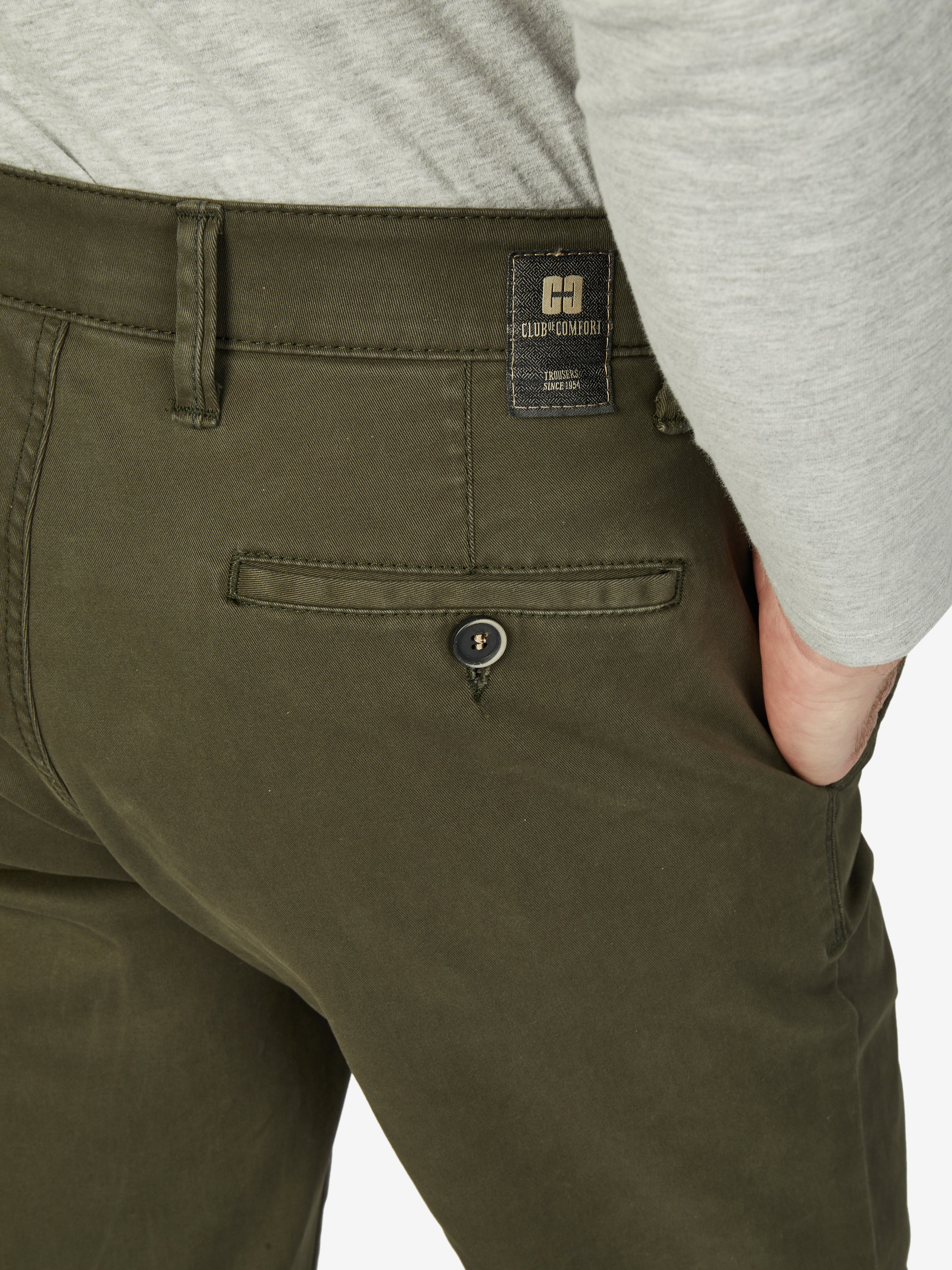 Nahaufnahme einer dunkel khakifarbenen Flat Front-Hose von Club of Comfort mit elastischem Komfortbund, Hemdenstopper und schmaler Beinführung, aus elastischem Baumwoll-Gabardine mit High Stretch, Gewicht 450 g/lfm, im Herbst/Winter-Design.