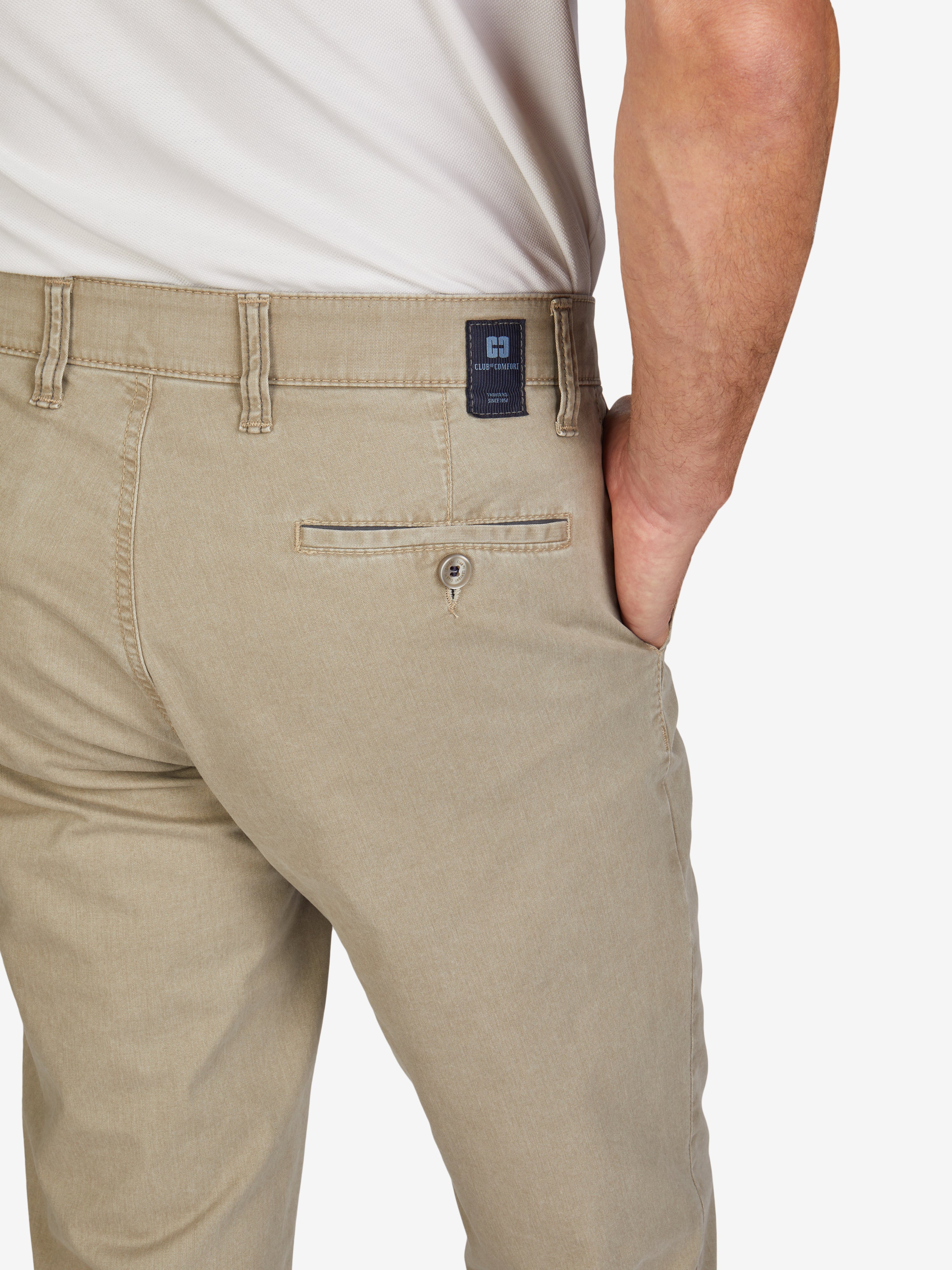 Nahaufnahme einer graubeigen Flat Front-Hose von Club of Comfort, mit elastischem Komfortbund, Hemdenstopper, seitlichen und Gesäßtaschen mit dezenter Kontrastpaspelierung, aus Baumwoll Broken-Twill mit High Stretch, sommerlicher Fade-Out-Färbung und regulärer Leibhöhe, geeignet für Frühling/Sommer, in schlanker Passform.