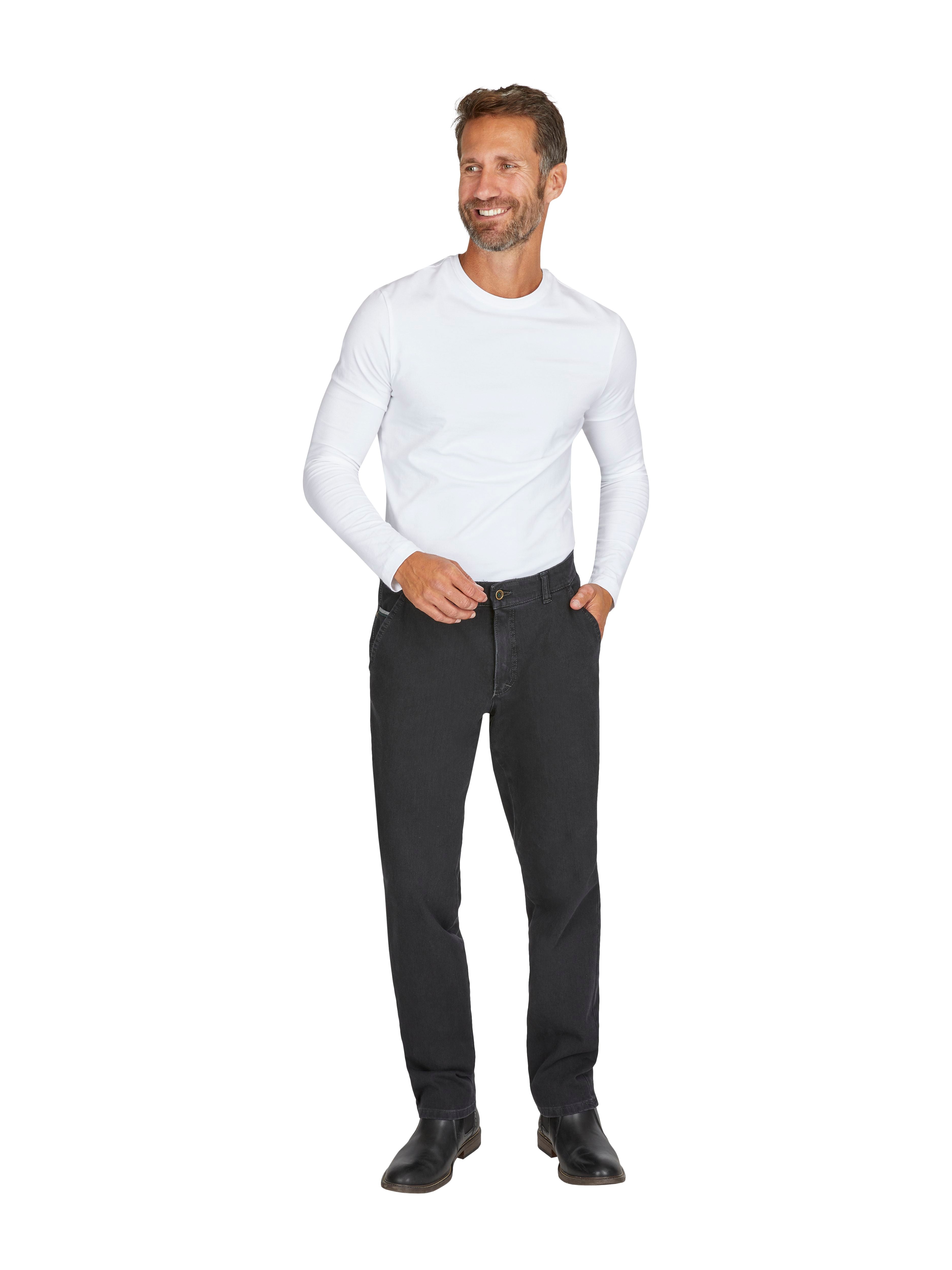 Mann trägt eine schwarze GARVEY 7054 Flat Front-Hose in anthrazit, kombiniert mit einem weißen Langarm-Shirt, steht vor neutralem Hintergrund, die Hose hat einen elastischen Komfortbund, Münztasche an der rechten Seite, und zeigt eine schmale Beinpassform.