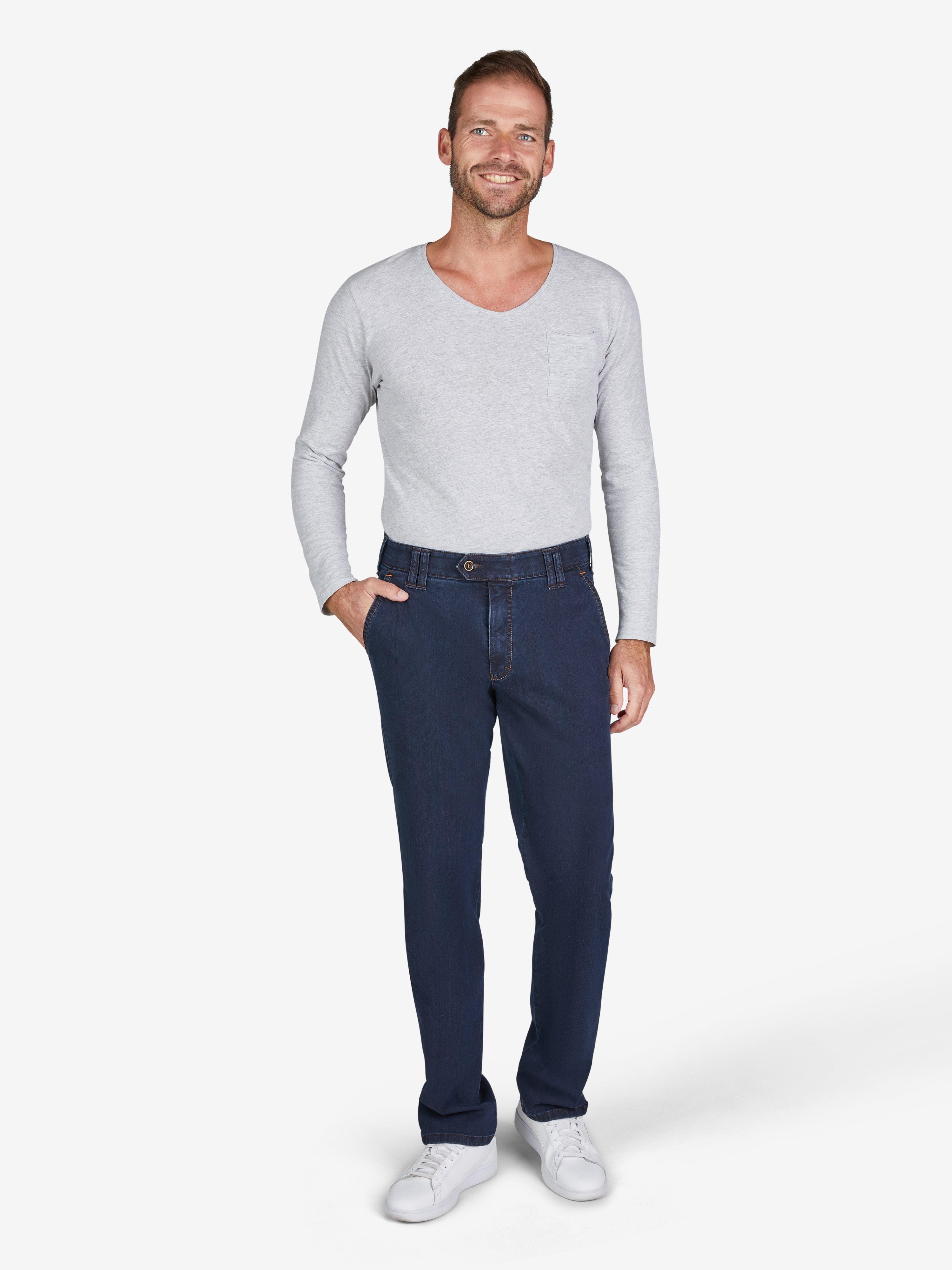 Mann trägt dunkelblaue GARVEY 7915 Flat Front-Hose mit elastischem Komfortbund, Hemdstopper und Bundverlängerung, aus hoch elastischem Super High Stretch-Denim mit formstabiler Lycra dual-FX®-Technologie. Passend für Regular Fit, schmalere Fußweite, made in Green by Oeko-Tex.
