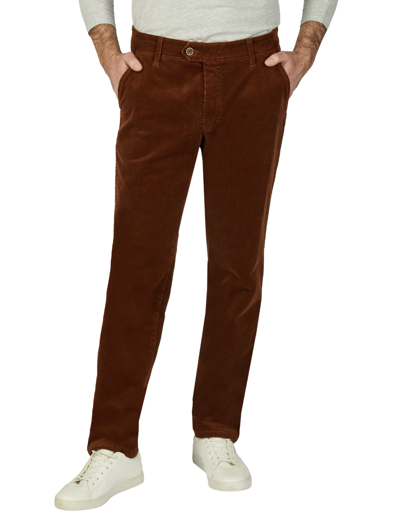 Bayerische braune Cordhosen, getragen von einer Person, die eine graue langärmlige Oberbekleidung trägt. Die Hose hat seitliche Taschen, eine Gürtelschlaufe und ist für einen klassischen, lässigen Look.