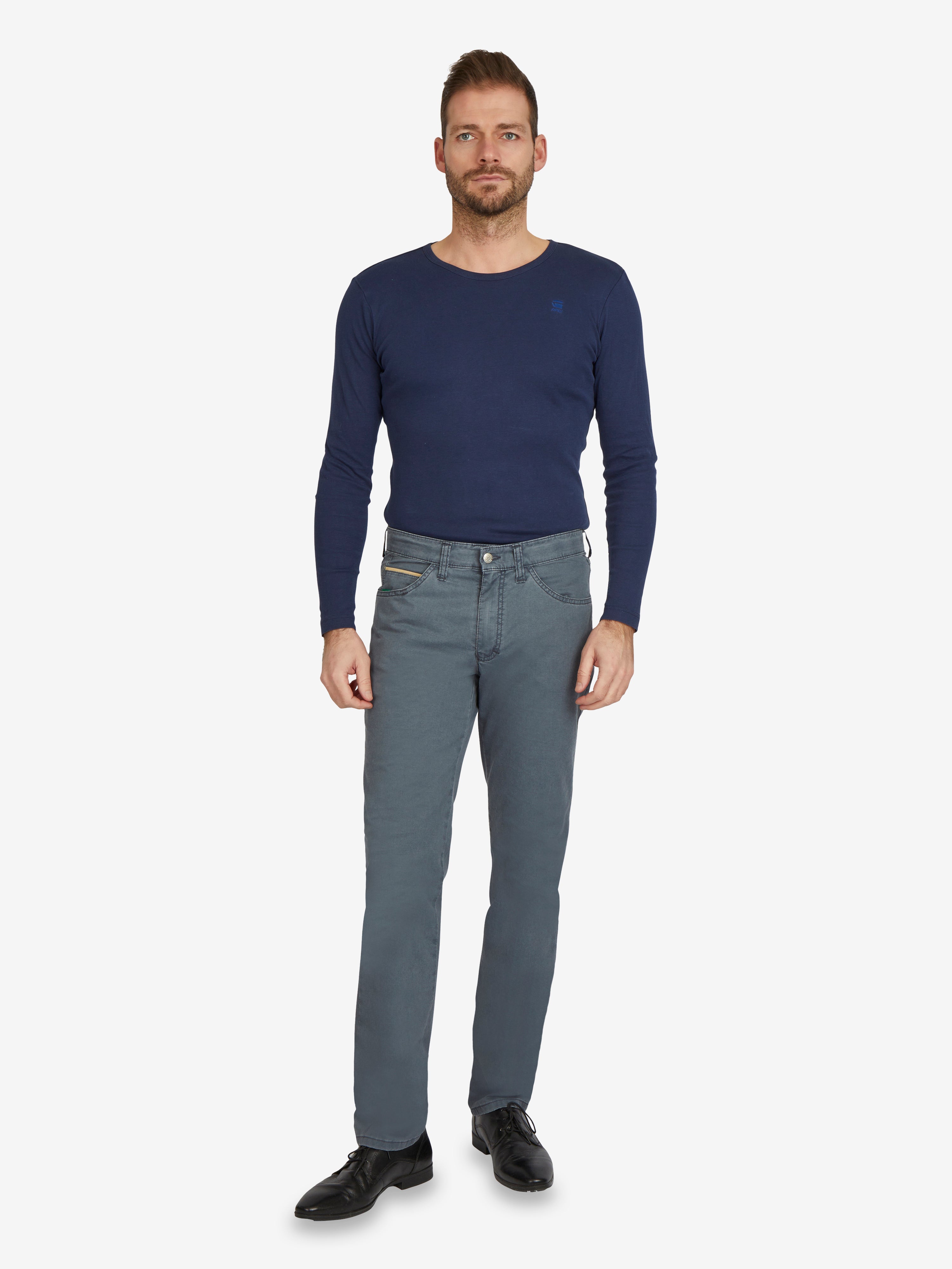 Mann trägt eine mittelblaue Hose HENRY 7323 von Club of Comfort mit 6-Pocket, Komfortbund, Smart Phone Tasche, High Stretch, recycelter Coolmax EcoMade-Faser, normale Leibhöhe, schlankes Bein, in einem hellblauen, schlichten Design, kombiniert mit einem blauen Langarmshirt.