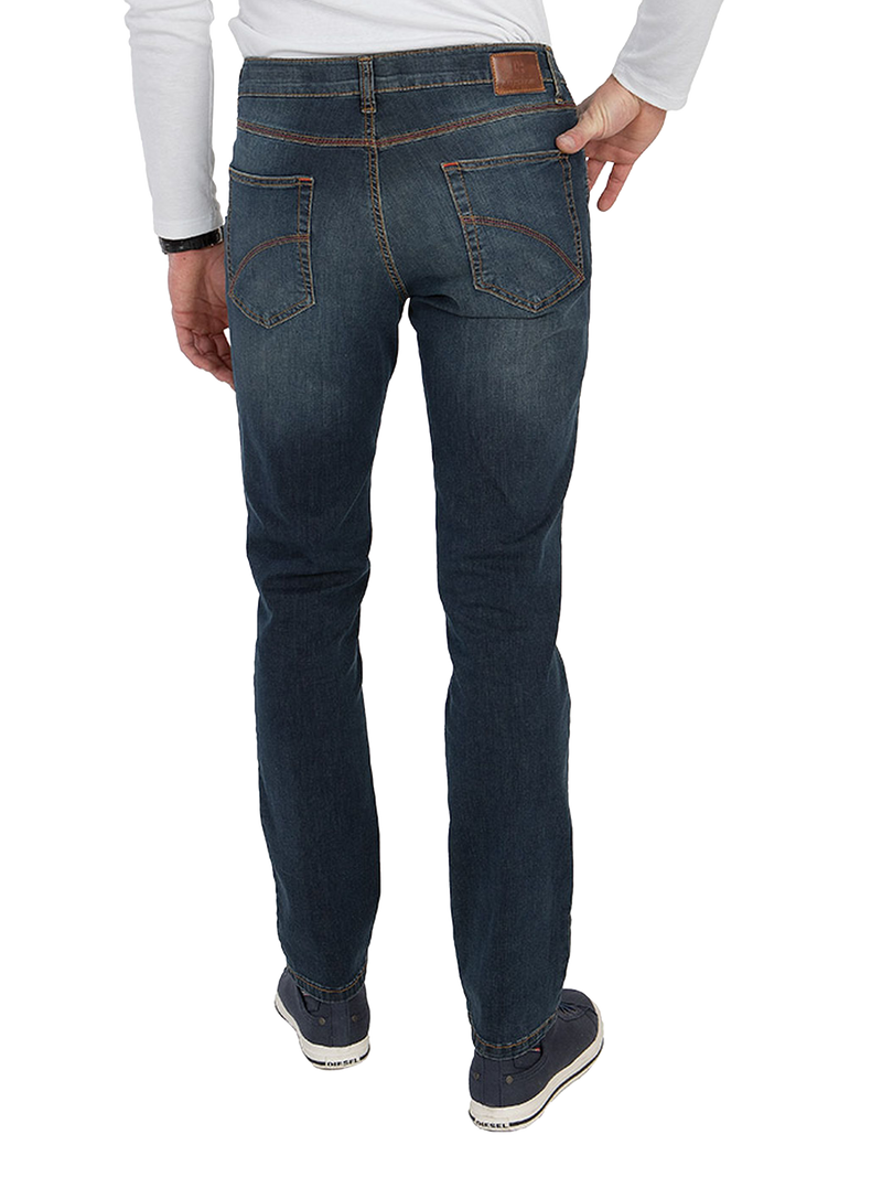 Blick auf eine Person in dunkelblauen Jeans, die seitlich stehen. Die Jeans haben zwei Rückentaschen mit braunen Nähten und einen braunen Lederetikett am Bund. Die Person trägt eine weiße, langärmlige Oberbekleidung, eine schwarze Armbanduhr und graue Sneaker.