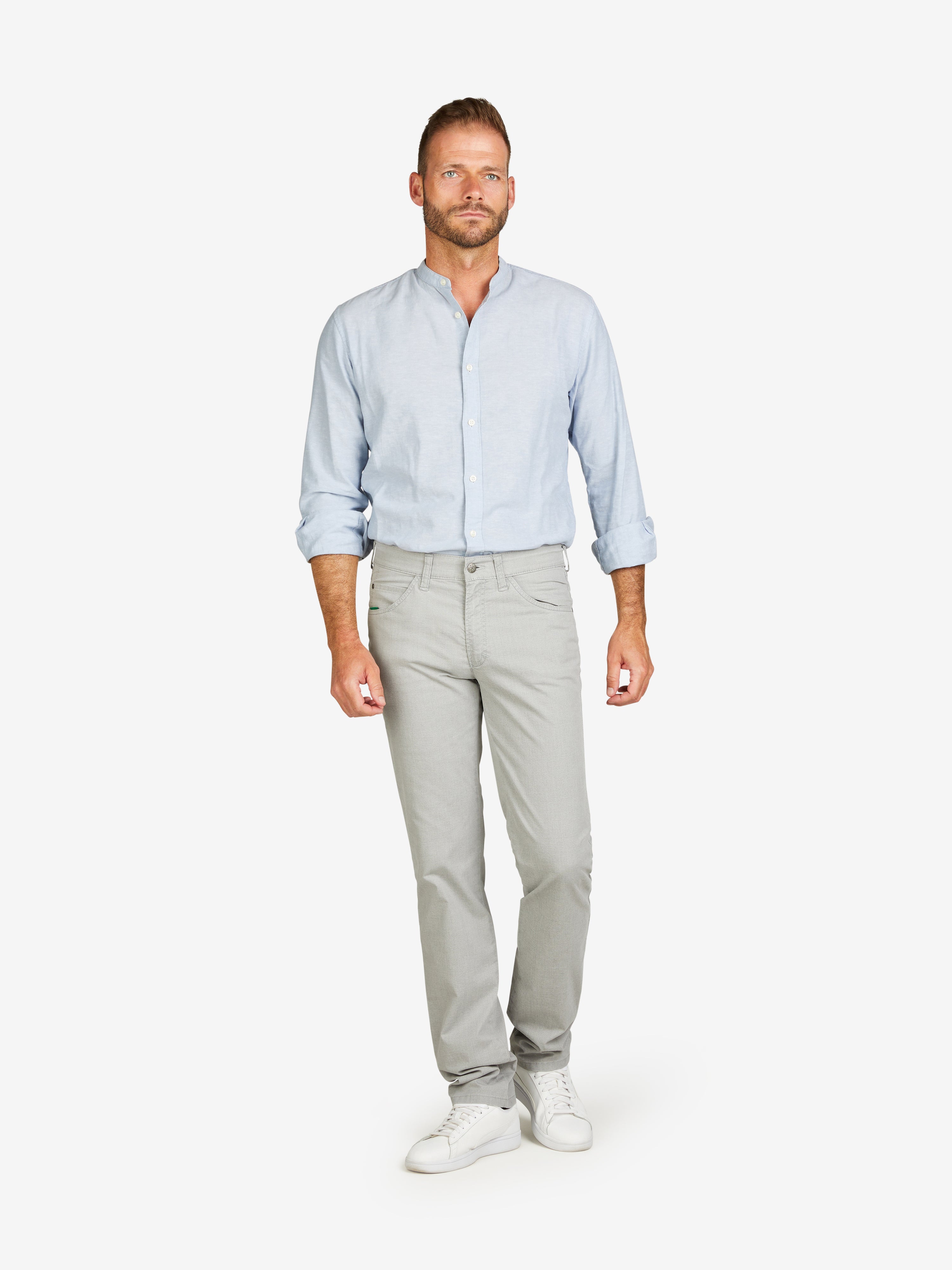 Mann in hellblauem Hemd und hellgrauer Baumwollhose mit 5-Pocket-Design, elastischem Komfortbund, Mobile Pocket, Regular Fit, hergestellt von Club of Comfort, auf weißem Hintergrund.