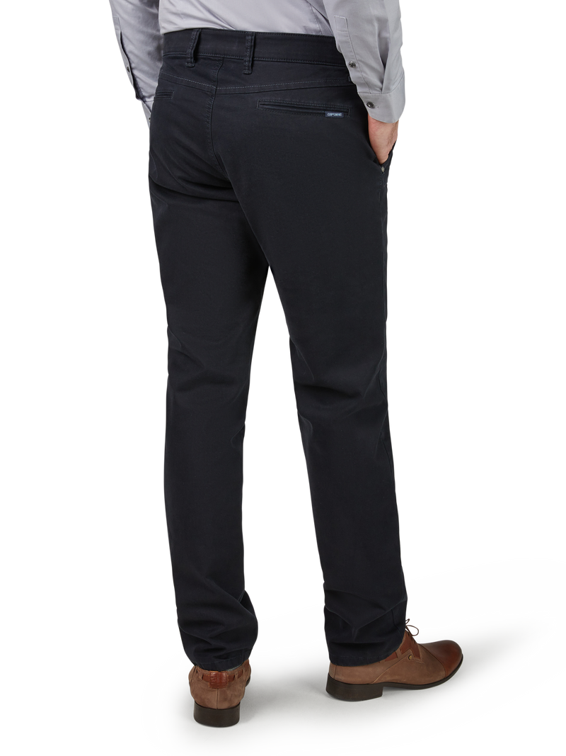 Ein Mann trägt schwarze Anzughosen, die hinten eine kleine Reißverschlusstasche haben. Er hat eine graue Jacke und braune Lederschuhe an. Sein Oberkörper ist im Bild nicht sichtbar.