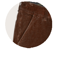 Nahaufnahme eines braunen Cordhosenstoffs mit sichtbarer Tasche und Nähte, detailreiche Textur des samtartigen Materials deutlich erkennbar.