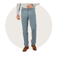 Ein Mann trägt eine hellblaue Jeans, einen grauen Pullover und braune Schuhe.