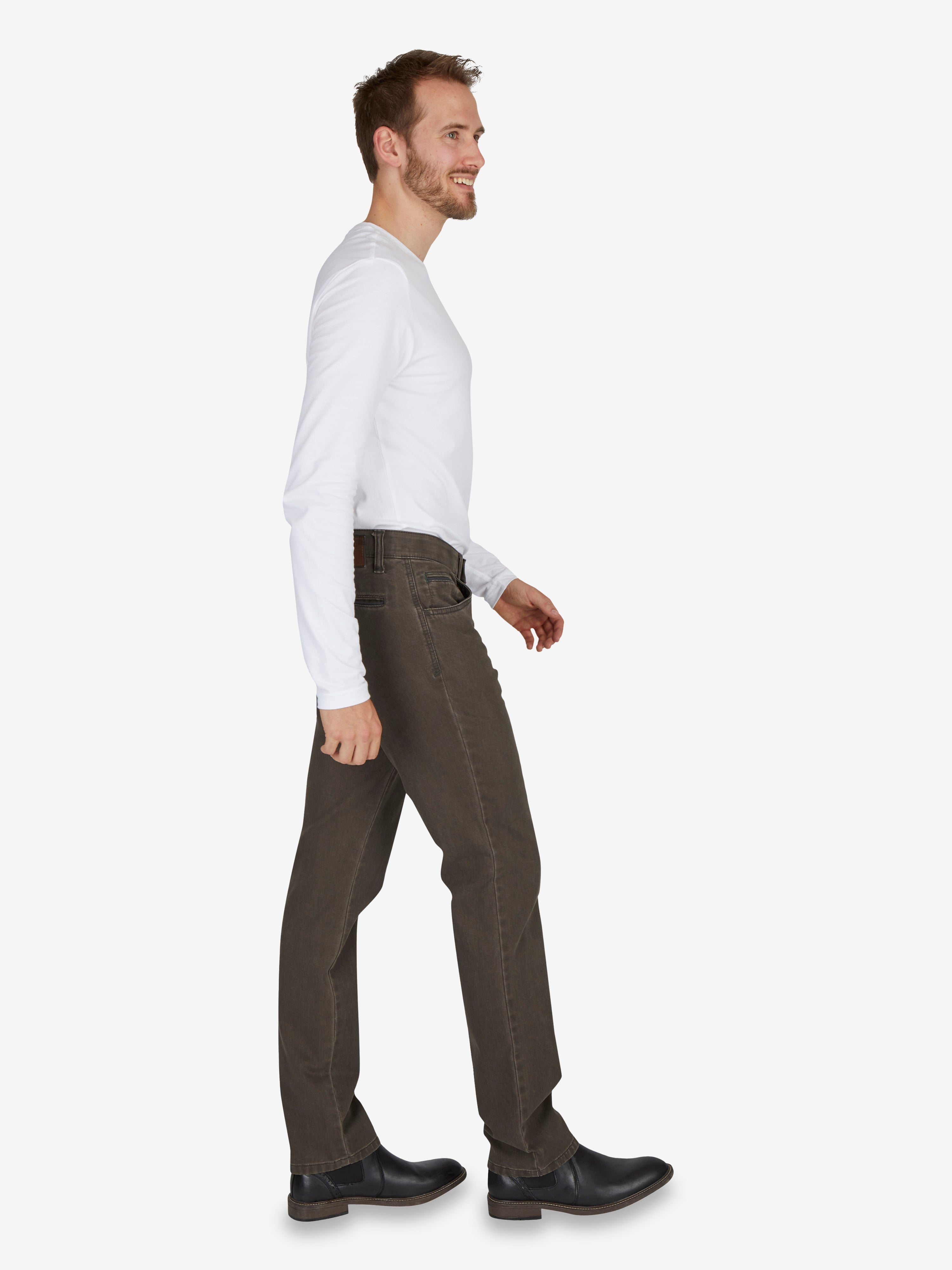 Mann trägt eine steingraue, modifizierte 5-Pocket-Hose MARVIN 7218 von Club of Comfort mit Regular Fit, elastischem Comfortbund, Hemdenstopper,High Stretch und doppelt paspelierter Münztasche, aus Pima-Baumwolle in Mikrostruktur, in Herbst/Winter-Farbfamilie Grau, modelle in normaler Leibhöhe, schlankes Bein, schmaler Fußweite.