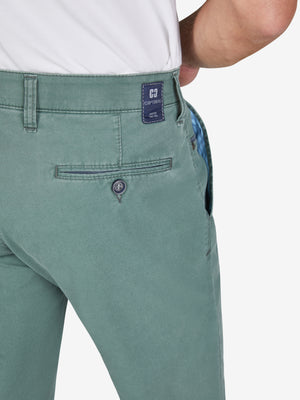 Nahe.Bild eines Mannes trägt eine blau-grüne Flat Front-Hose mit elastischem Komfortbund, Hemdstopper und Münztasche. Die Hose besteht aus leichtem, recyceltem Baumwoll-High Stretch mit Coolmax EcoMade Faser, reguliert die Temperatur, hat eine schmale Fußweite und eine normale Leibhöhe.