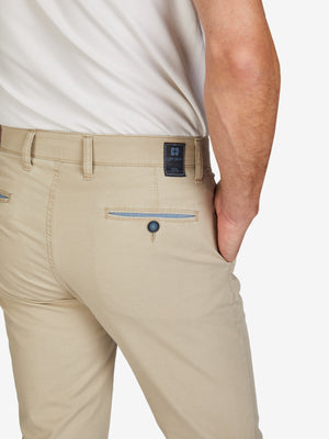 Nahaufnahme einer beige GARVEY 7323 Flat Front-Hose mit Komfortbund, Hemdstopper und Münztasche in der rechten Seitentasche. Die Hose ist aus leichtem Baumwoll-High Stretch mit Coolmax EcoMade-Faser für Klimaregulierung, hergestellt in Grün.