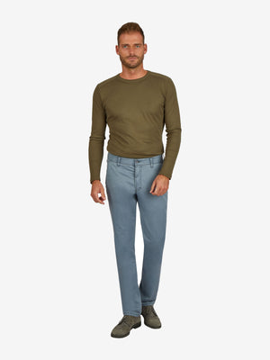 Mann trägt eine rauchblau GARVEY Flat Front-Hose aus Baumwoll-High Stretch mit elastischem Komfortbund, Hemdenstopper und normaler Leibhöhe, kombiniert mit einem grünen Longsleeve.