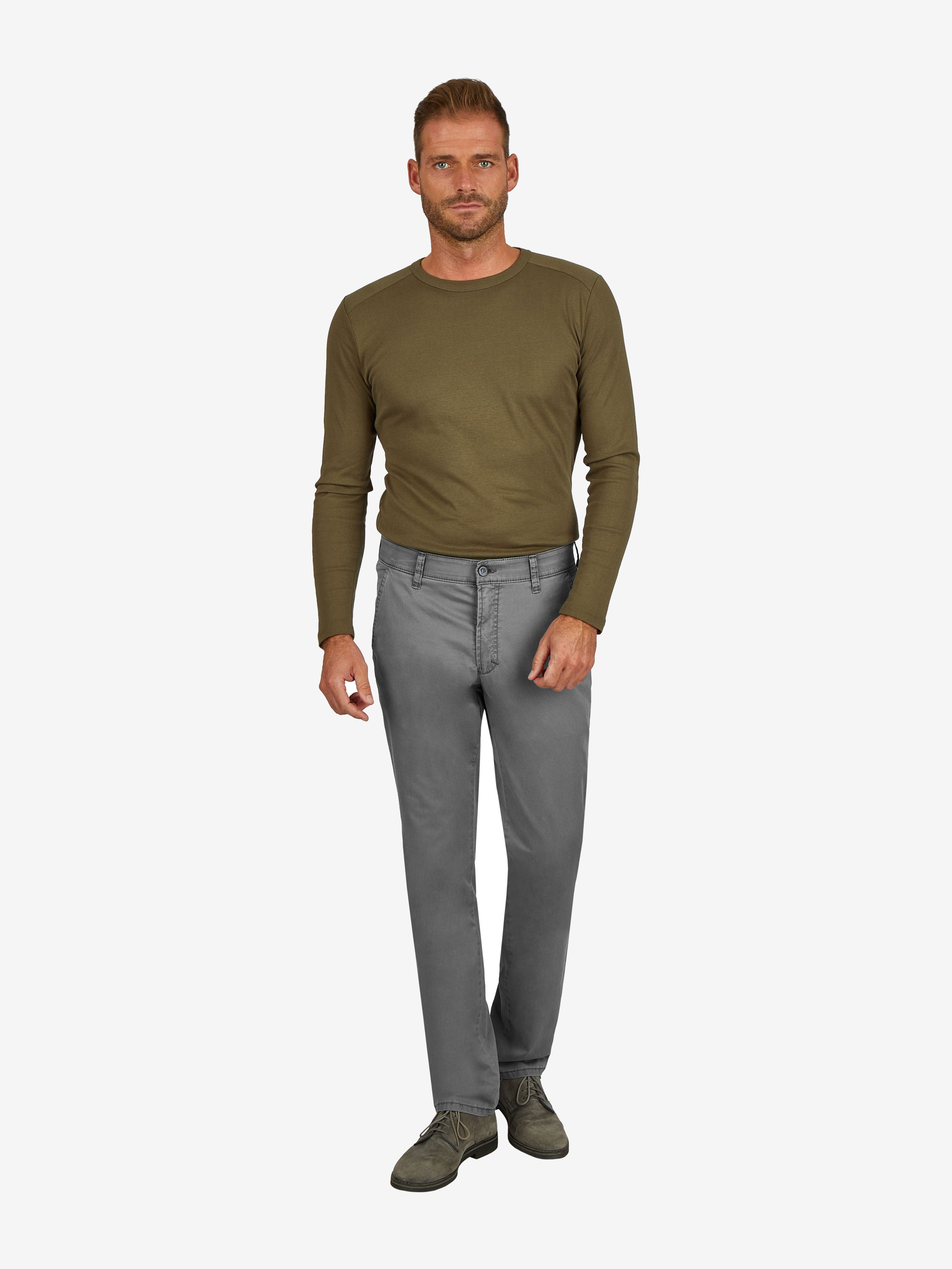 Mann trägt eine graue GARVEY 7708 Flat Front-Hose aus Baumwoll-High Stretch mit elastischem Komfortbund, Hemdenstopper und normaler Leibhöhe, kombiniert mit einem grünen Langarmshirt.