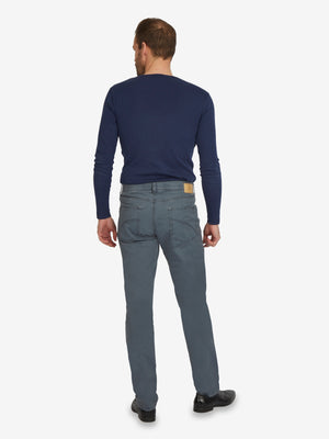 Mann trägt eine dunkelblaue Henry 7323 5-Pocket-Hose aus Baumwolle mit elastischem Doppelstoffbund, Hemdstopper und separater "Mobile Pocket" in der rechten Tasche, kombiniert mit einem blauen Langarmshirt.